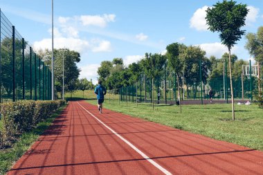 Atletik genç adam koşuyor. Egzersiz, kentsel alanda esneme ya da sabah park. Özgüven, refah ve spor kavramları