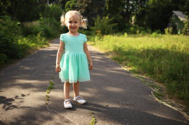 Mutlu, sarışın bir kızın portresi. Yakın plan. 3 tane Kafkasyalı küçük kız dışarıda yürürken gülümsüyor. Dans eden ve bağıran çocuk farklı duygular gösteriyor..