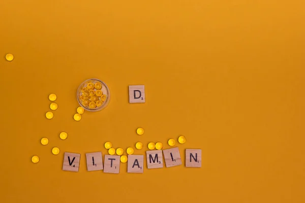 Muitas pílulas transparentes sol vitamina D3 em um fundo colorido. Suplementos de saúde e medicamentos — Fotografia de Stock