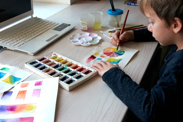 Αγόρι ζωγραφίζοντας εικόνες με υδατογραφίες κατά τη διάρκεια μάθημα τέχνης σε απευθείας σύνδεση — Φωτογραφία Αρχείου