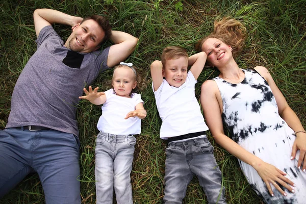 Feliz familia amorosa con dos hijos, hijo e hija jugando y abrazándose. Caminata familiar. Feliz Día de las Madres. — Foto de Stock