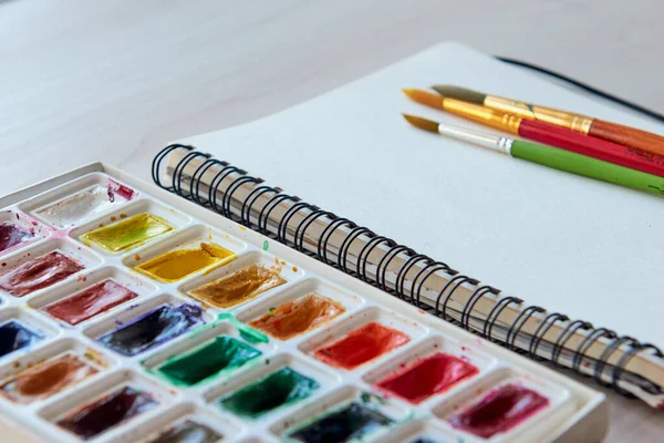 Artist\'s workplace. Art supplies brushes, watercolor paints, sketchbook. Art studio. Drawing lessons. Creative workshop. Design place.