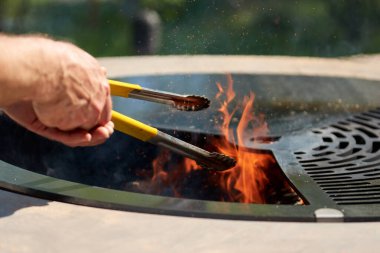 Tencere dibin kara seninki benden kara, seninki benden kara. Yuvarlak masa pişirme yüzeyi. Arka bahçede paslanmaz çelik ızgaralı barbekü ızgarası hazır ızgara yemeği. İçinde alevler olan ızgara..
