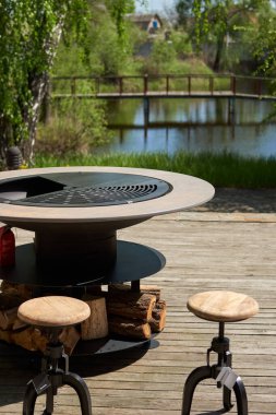 Tencere dibin kara seninki benden kara, seninki benden kara. Yuvarlak masa pişirme yüzeyi. Arka bahçede paslanmaz çelik ızgaralı barbekü ızgarası hazır ızgara yemeği. İçinde alevler olan ızgara..