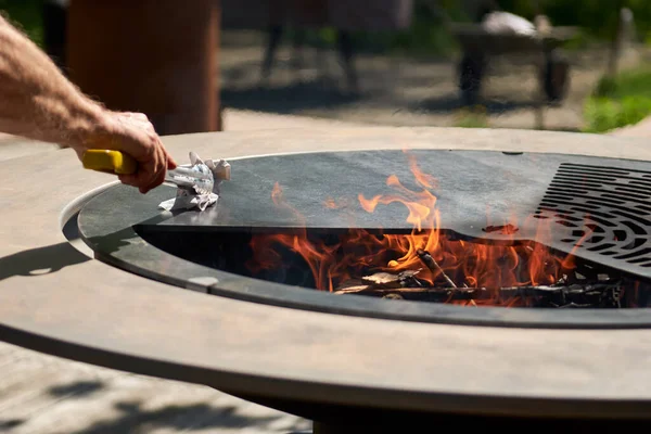 Tencere dibin kara seninki benden kara, seninki benden kara. Yuvarlak masa pişirme yüzeyi. Arka bahçede paslanmaz çelik ızgaralı barbekü ızgarası hazır ızgara yemeği. İçinde alevler olan ızgara..