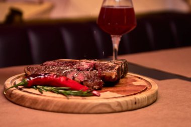 Biberiye dalıyla ızgara biftek, biber ve tuz. Lokantada ya da barda bir bardak bira. Usta şef lezzetli ızgara ızgara sebzeler pişiriyor..