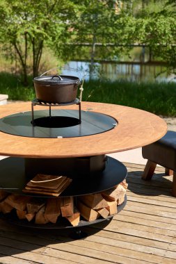 Tencere dibin kara seninki benden kara, seninki benden kara. Yuvarlak masa pişirme yüzeyi. Arka bahçede paslanmaz çelik ızgaralı barbekü ızgarası hazır ızgara yemeği. İçinde alevler olan ızgara..