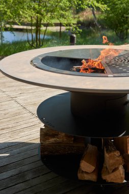 Tencere dibin kara seninki benden kara, seninki benden kara. Yuvarlak masa pişirme yüzeyi. Arka bahçede paslanmaz çelik ızgaralı barbekü ızgarası hazır ızgara yemeği. İçinde alevler olan ızgara..