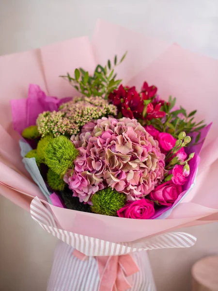 Taze, gür renkli karışık çiçekler buketi. Avrupa çiçekçi dükkânı konsepti. Çiçek teslimatı. Çiçekçinin dolabında çiçek açan güzel çiçekler.