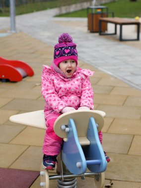Çocuklar parkta oynarlar. Mutlu gülüşler oğlanlar ve kızlar, salıncakta sallanarak ve tırmanarak eğlenin