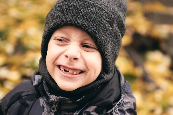 Jongen heeft plezier in mooi park met droge gele en rode bladeren. Herfst familie wandeling in het bos — Stockfoto