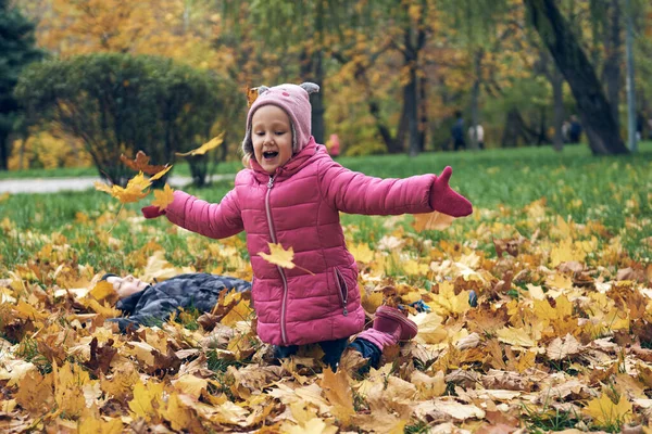 Menina se divertindo no belo parque com folhas secas amarelas e vermelhas. Passeio familiar de outono na floresta — Fotografia de Stock