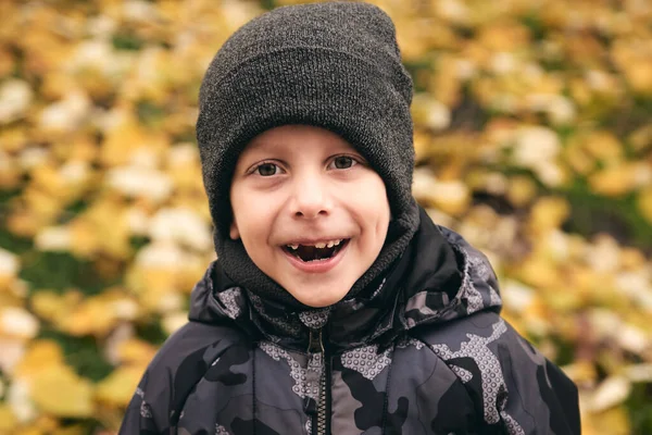 Jongen heeft plezier in mooi park met droge gele en rode bladeren. Herfst familie wandeling in het bos — Stockfoto