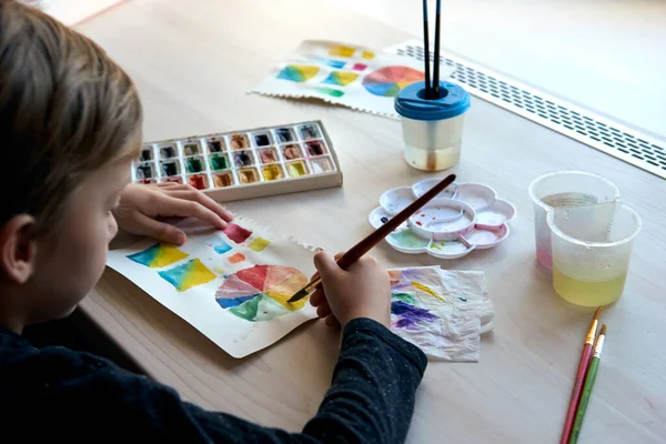 Chico pintura cuadros con acuarela pinturas durante la lección de arte en línea —  Fotos de Stock