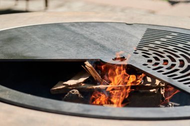 Tencere dibin kara seninki benden kara, seninki benden kara. Yuvarlak masa pişirme yüzeyi. Arka bahçede paslanmaz çelik ızgaralı barbekü ızgarası hazır ızgara yemeği. İçinde alevler olan ızgara..