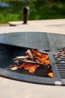 Tencere dibin kara seninki benden kara, seninki benden kara. Yuvarlak masa pişirme yüzeyi. Arka bahçede paslanmaz çelik ızgaralı barbekü ızgarası hazır ızgara yemeği. İçinde alevler olan ızgara..