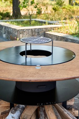 Demir Şebeke 'li Kettle Grill Pit. Yakacak odunlu yuvarlak masa pişirme yüzeyi. Arka bahçede paslanmaz çelik ızgaralı barbekü ızgarası hazır ızgara yemeği. İçinde alevler olan ızgara..