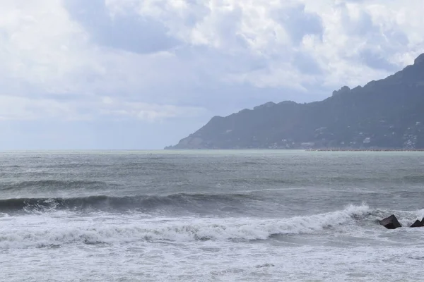 Deniz manzarası bulutlu ve dalgalı gökyüzü ile özel bir atmosfer yaratıyor.