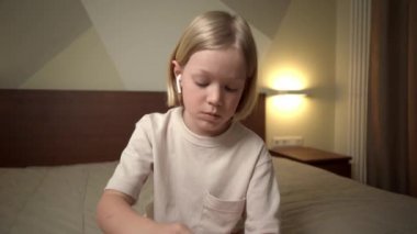 Evdeki çocuk kulaklık ve akıllı telefon kullanıyor..