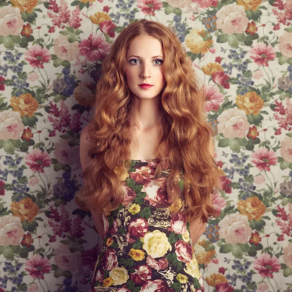 Hermosa chica sobre un fondo floral . — Foto de Stock