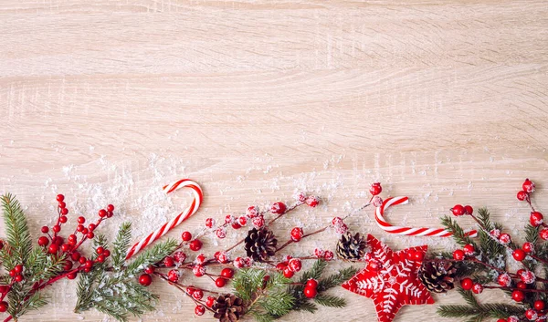 クリスマスフレームの背景のフラットレイアウトビュー 赤い果実の枝 フェルトの星の装飾品 赤いキャンディーの杖とトウヒの枝 コピースペース — ストック写真