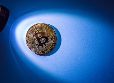 Kripto para konsepti. Altın bitcoin metal madeni para üzerinde spot ışığı mavi arka planda bir sürü kopya alanı ile.