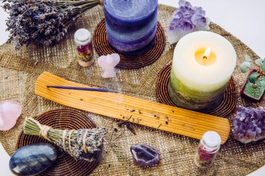 Evdeki küçük feng shui mihrabı yaprak şeklindeki masa paspası üzerinde, arka planda karlı İskandinav doğası. Tütsü tüten mum, dekorasyon için değerli taşlar..