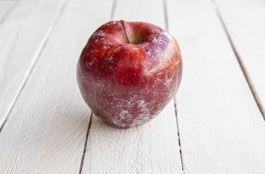 Beyaz koruma katmanlı kırmızı elma evde elma yıkadıktan sonra kısmen eriyor. Dükkanda satmadan önce, elmaları taze tutmak için yenilebilir sentetik balmumu sürüyorlar. Dikkatli yıka..