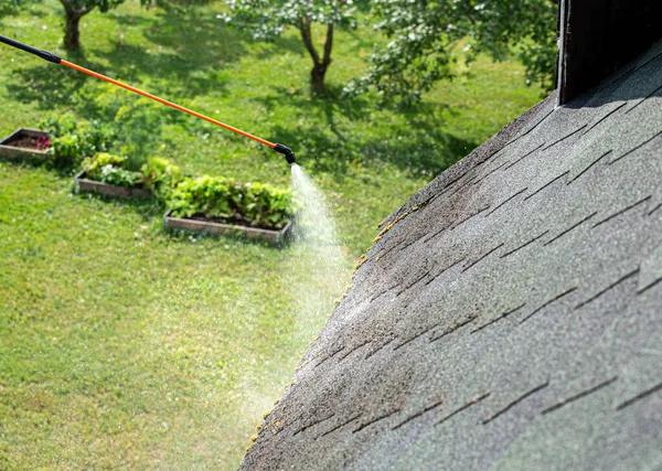 집안의 지붕에 물질을 제거하는 이끼를 뿌린다 — 스톡 사진