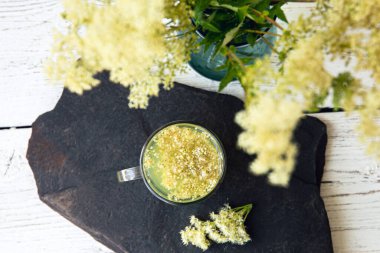Yukarıdan bakıldığında, taze Meadowsweet çiçeği, vazodaki Filipendula ulmaria, cam vazodaki bitki çayıyla aynı.. 
