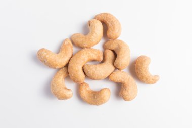 Beyaz arka plan üzerinde tuzlu ve kavrulmuş kaju fıstığı