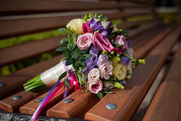 A wedding bouquet lies on the wooden bench — Stock Photo, Image