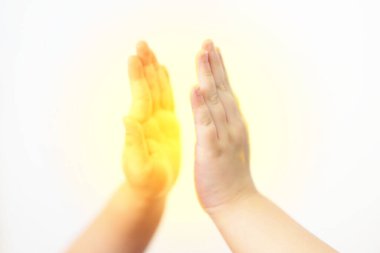 Çocuklar beyaz arka planda beşlik çakıyor. Güneş ışığıyla işbirliği konseptiyle kapatılıyor.