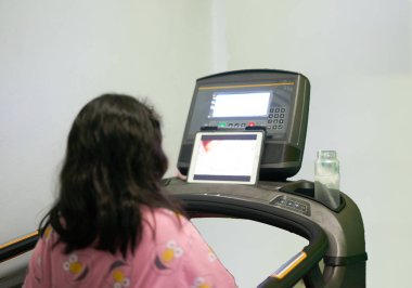 online eğitim tableti kursuyla koşu bandında koşan bir çocuk.