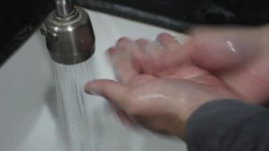 Ellerin üst görüntüsü leğende sabunla yıkanır.