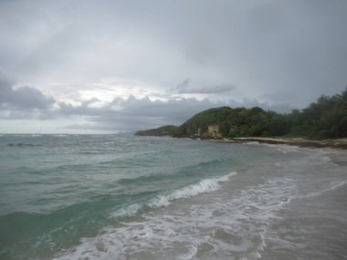 Dalgalar ve deniz bulutlu bir gökyüzünün altında