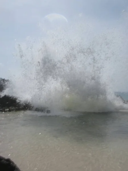 強力な波はスプレーを作成することで岩に当たる — ストック写真