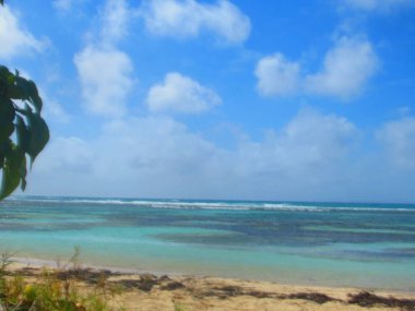 Beyaz kumsal ve turkuaz deniz Bulutlu gökyüzünün altında
