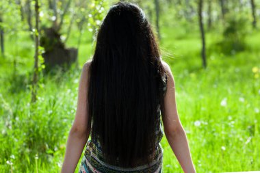 Yeşil çimlerde oturan bir kadın.