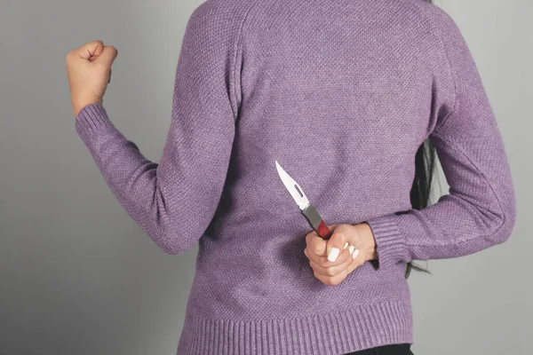 灰色の背景にナイフを持っている女性の手 — ストック写真