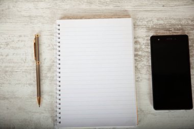 Ahşap masadaki kalem ve boş kağıt.