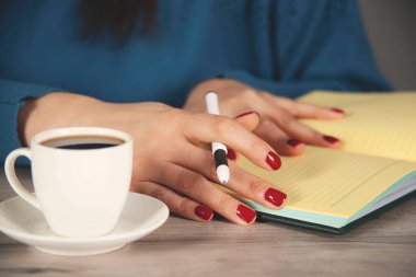 Çalışma masasında not defteri olan kadın el kalemi.