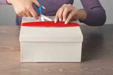 Kadın, makas ve bant masanın üzerinde.