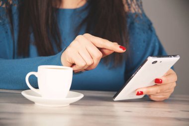  Masasında kahve olan kadın cep telefonu.