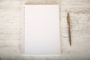 Not defteri ve kalem masaya.