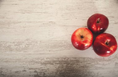 Masadaki kırmızı elmalar hafif arkaplanda