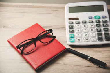 Masasında kalem ve gözlük olan not defteri.