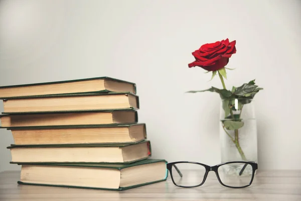 red rose and book on desk