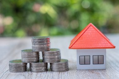 Turuncu çatı evleri ve birikmiş paralar İş büyümesi Emlak yatırımları ve ev kredileri, finansal gayrimenkul kavramları.