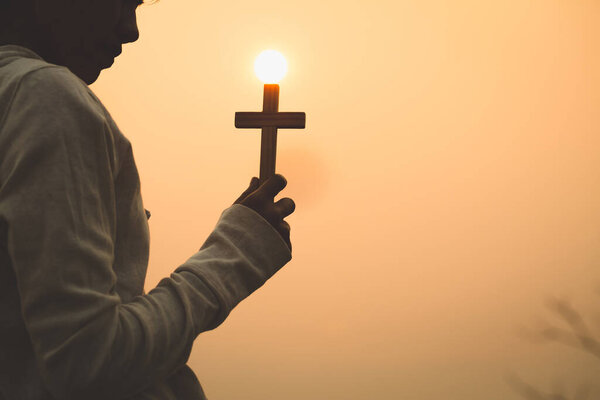 A young woman with a cross Pray from God with the power and power of holiness, which brings luck and shows forgiveness with the power of religion, faith, worship, Christian thought.